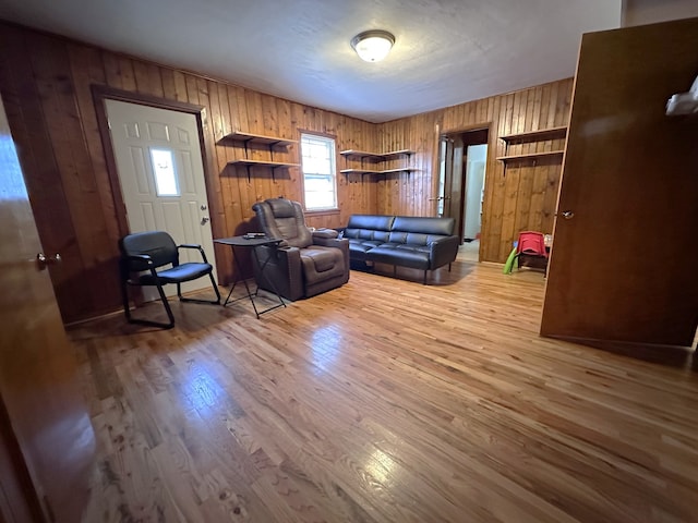 living room featuring light wood-style floors and wooden walls