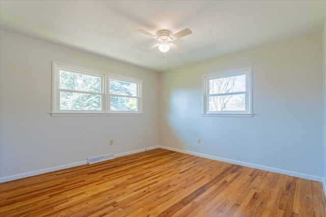 unfurnished room featuring visible vents, light wood-style floors, a healthy amount of sunlight, and ceiling fan