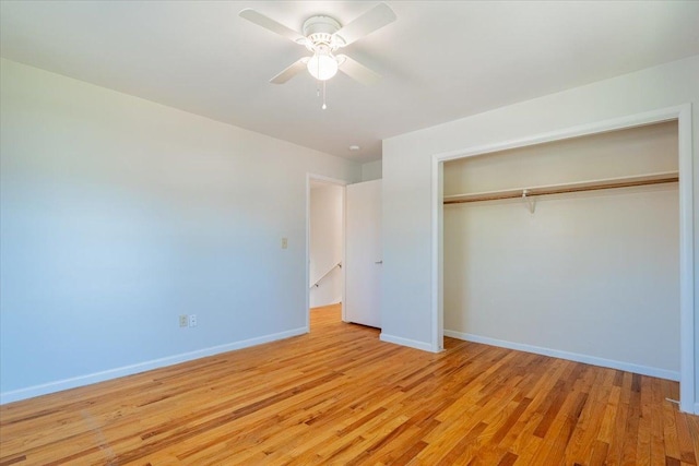 unfurnished bedroom featuring ceiling fan, light wood-style floors, a closet, and baseboards