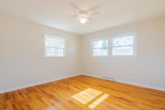 spare room with visible vents, light wood-style floors, baseboards, and ceiling fan