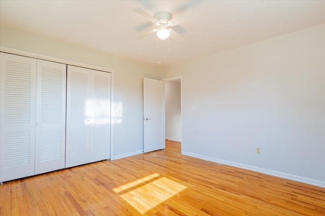 unfurnished bedroom with a closet, baseboards, light wood-style floors, and ceiling fan