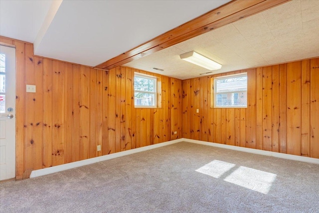 below grade area featuring carpet flooring, wood walls, and baseboards