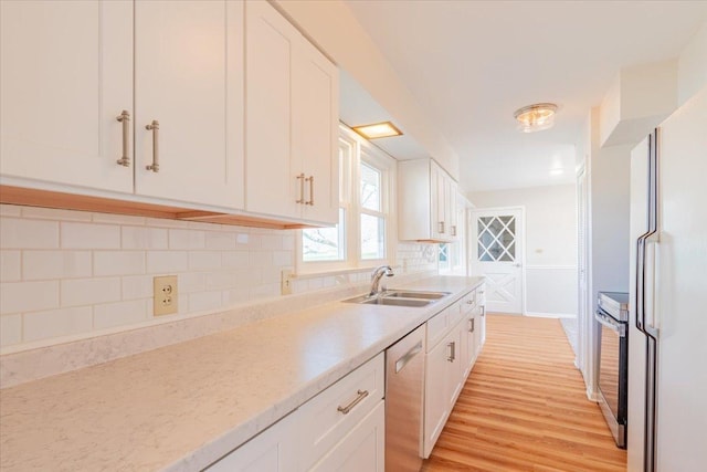 kitchen featuring a sink, stainless steel appliances, and white cabinets