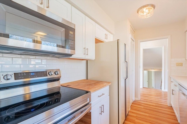 kitchen featuring stainless steel appliances, light wood-style floors, white cabinets, light countertops, and decorative backsplash