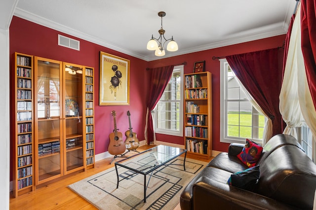 4201 Brittany Trail Dr, Champaign, IL 61822 - living area featuring visible vents, crown molding, an inviting chandelier, wood finished floors, and baseboards