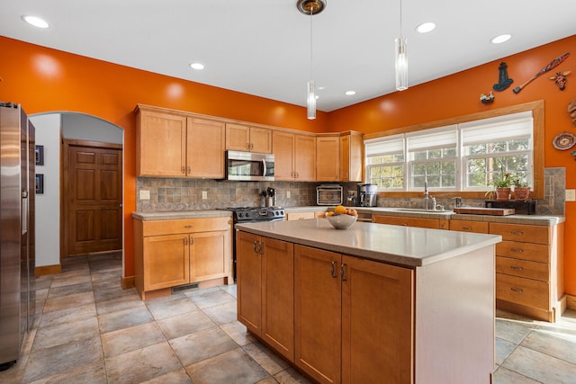 4201 Brittany Trail Dr, Champaign, IL 61822 - kitchen with a kitchen island, decorative light fixtures, appliances with stainless steel finishes, tasteful backsplash, and a sink