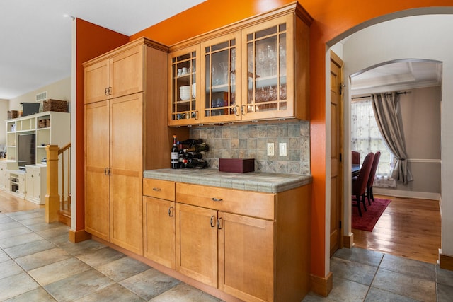 4201 Brittany Trail Dr, Champaign, IL 61822 - bar with backsplash, arched walkways, baseboards, and stone tile flooring