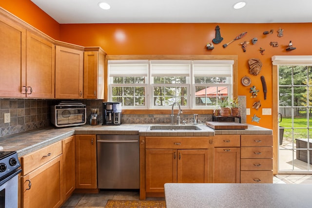 4201 Brittany Trail Dr, Champaign, IL 61822 - kitchen with stainless steel dishwasher, decorative backsplash, brown cabinetry, recessed lighting, and a sink