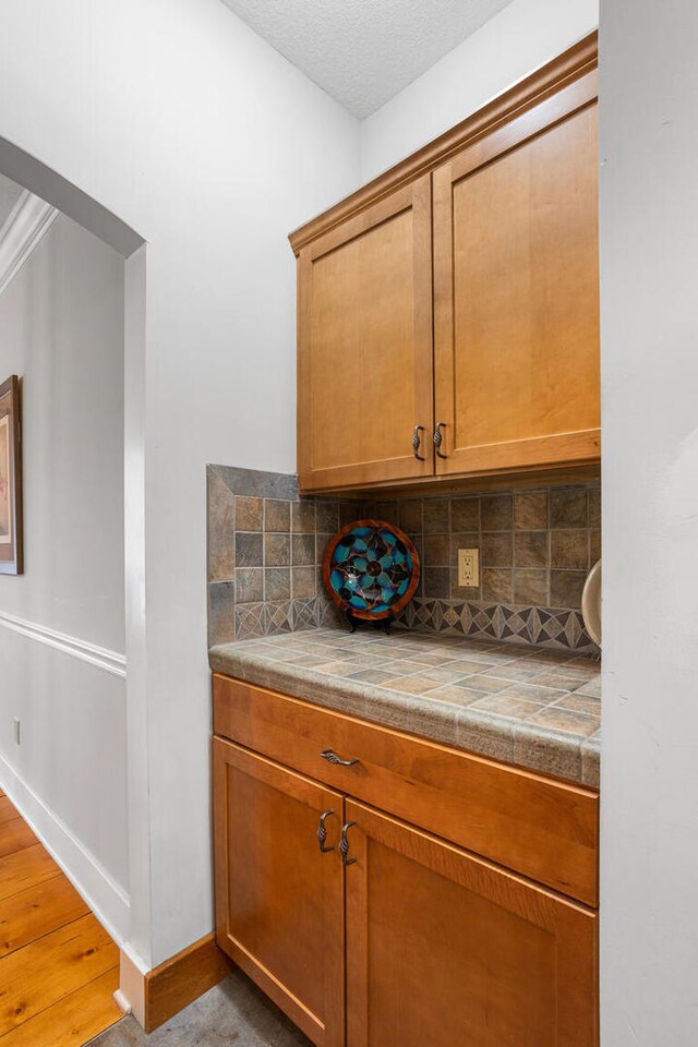 4201 Brittany Trail Dr, Champaign, IL 61822 - bar with light wood-type flooring, baseboards, and backsplash