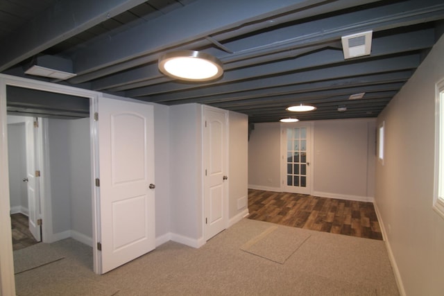 finished basement featuring visible vents, baseboards, wood finished floors, and carpet flooring