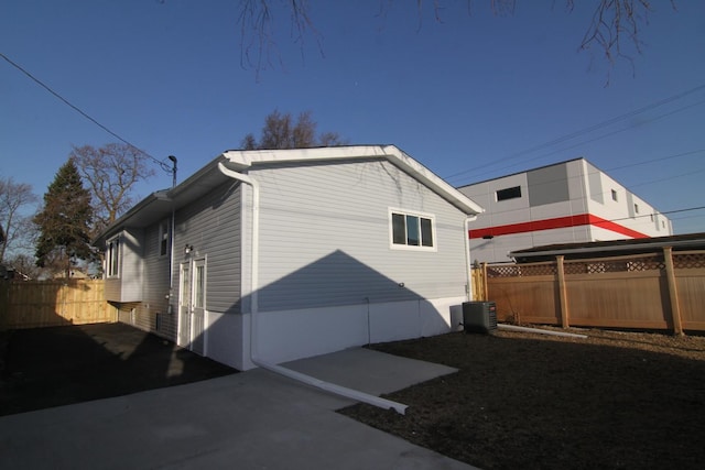 view of property exterior with fence and central AC