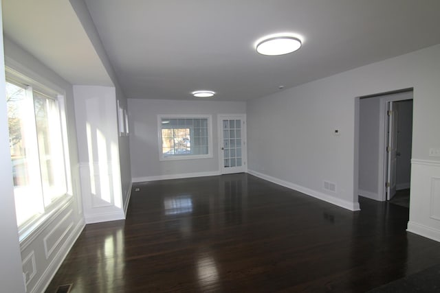 spare room with dark wood finished floors, baseboards, and visible vents