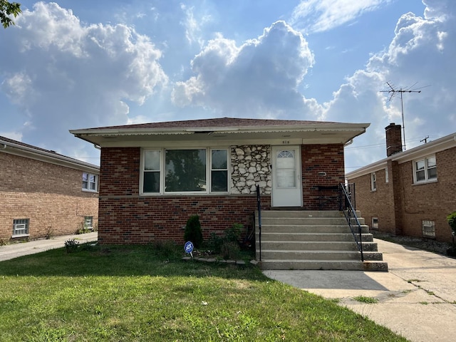 bungalow with a front yard and brick siding