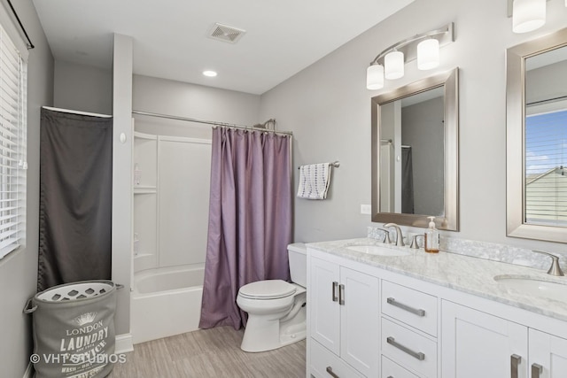 bathroom featuring double vanity, toilet, visible vents, and a sink