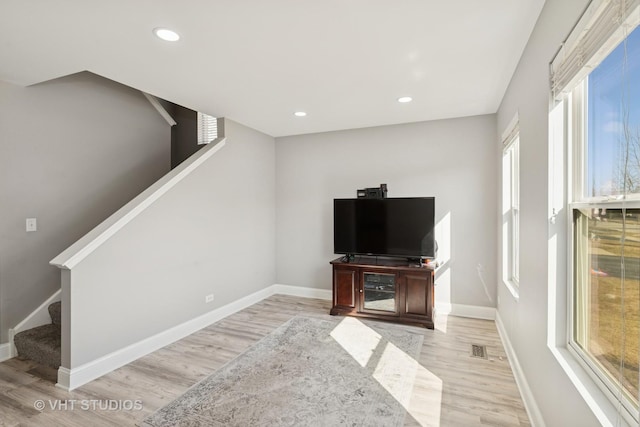 living room featuring visible vents, baseboards, light wood-style flooring, recessed lighting, and stairs