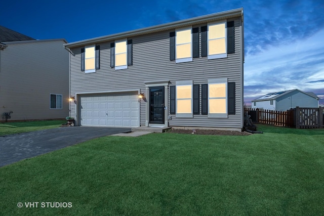 view of front facade featuring a garage, a front lawn, driveway, and fence