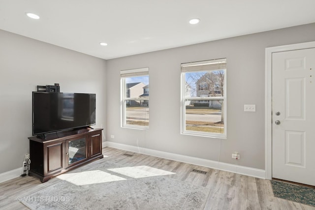 living area with light wood-type flooring and baseboards