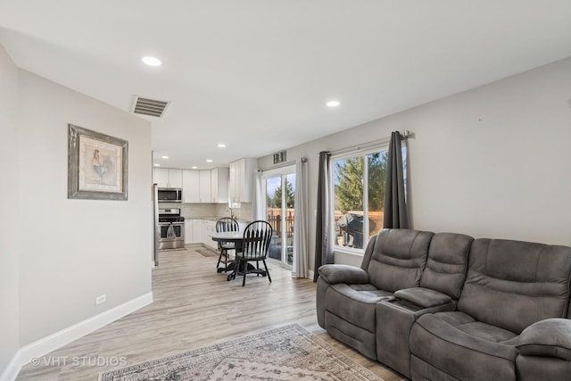 living area featuring recessed lighting, baseboards, visible vents, and light wood finished floors