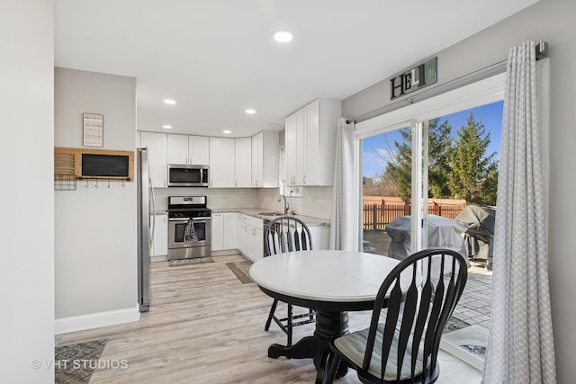 dining area with recessed lighting, baseboards, and light wood finished floors