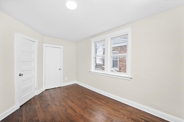 unfurnished bedroom featuring dark wood finished floors and baseboards