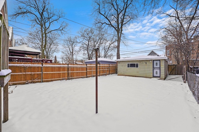 yard covered in snow featuring a gazebo, an outbuilding, and a fenced backyard