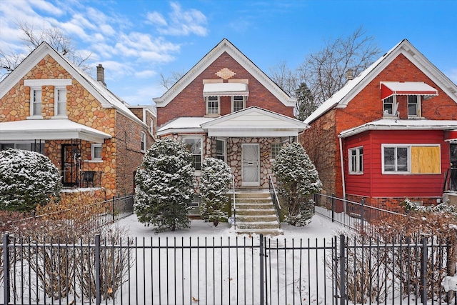 bungalow-style house with a fenced front yard and brick siding