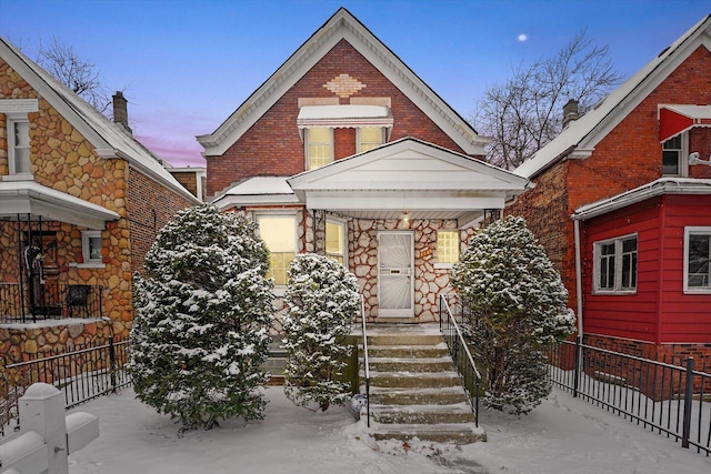 view of front facade with brick siding and fence