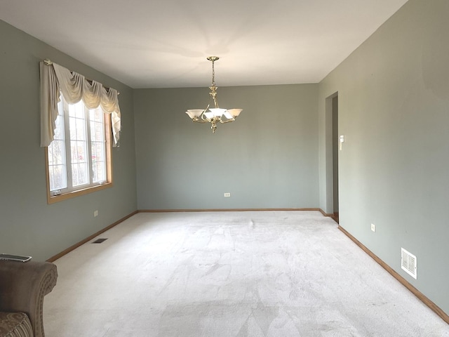 carpeted empty room with visible vents, baseboards, and a chandelier