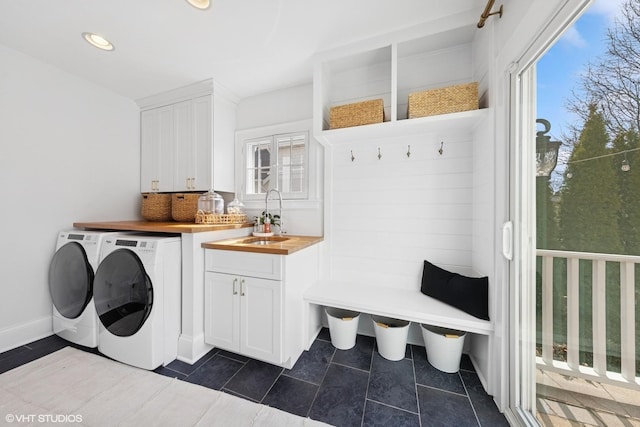 laundry room with recessed lighting, cabinet space, a sink, washer and dryer, and dark tile patterned floors