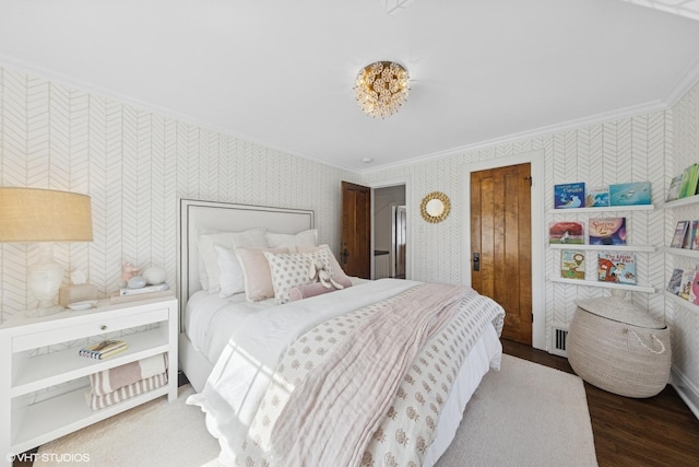 bedroom with visible vents, wood finished floors, ornamental molding, and wallpapered walls