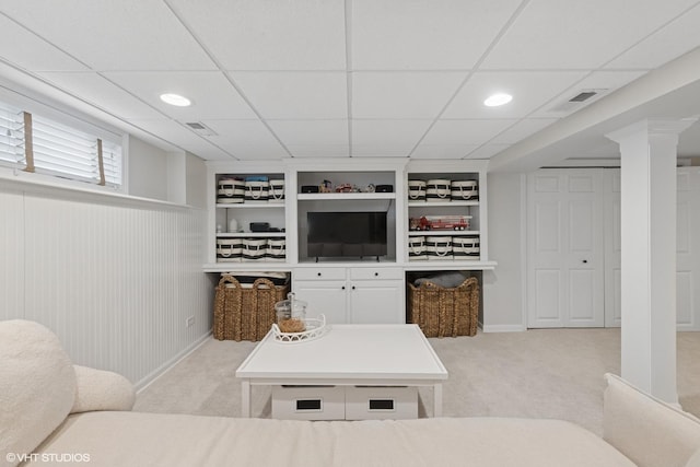 living room with built in features, visible vents, and light carpet