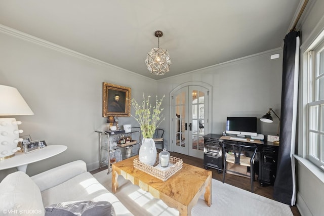 living area with wood finished floors, baseboards, french doors, crown molding, and a chandelier