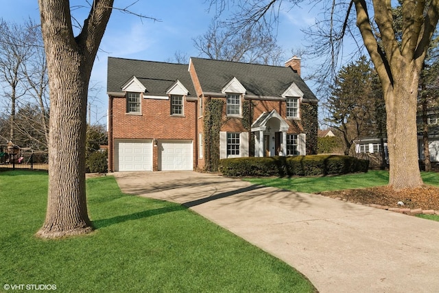 view of front facade with concrete driveway, a front yard, an attached garage, brick siding, and a chimney