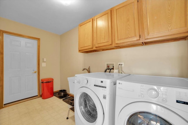 laundry room with washing machine and clothes dryer, light floors, and cabinet space