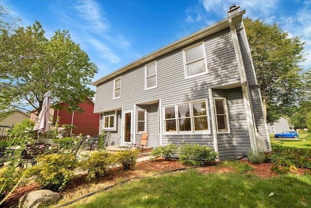 back of house featuring a chimney and a patio