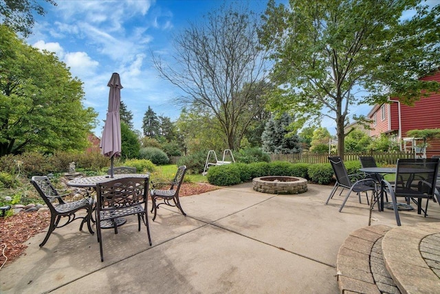 view of patio featuring a fire pit, outdoor dining area, and fence