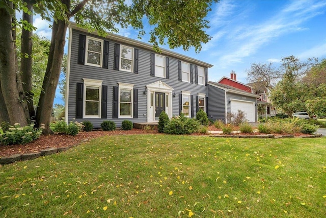 colonial home featuring a front lawn and a garage