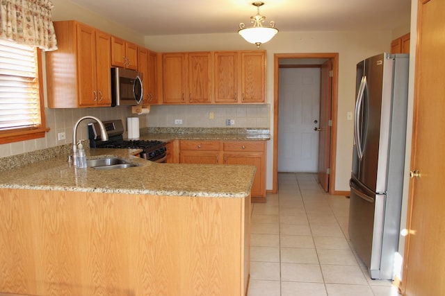 kitchen with a sink, stainless steel appliances, a peninsula, light tile patterned flooring, and decorative backsplash