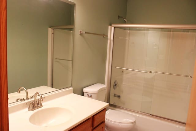 full bathroom with vanity, toilet, and combined bath / shower with glass door