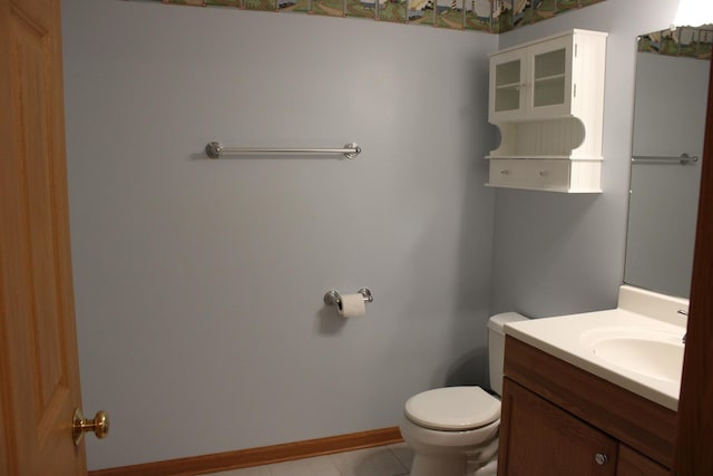 bathroom featuring baseboards, toilet, vanity, and tile patterned flooring