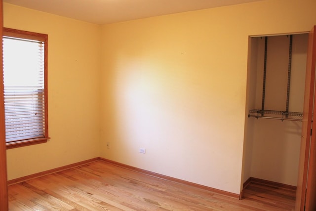 interior space featuring a closet, baseboards, and light wood-style flooring