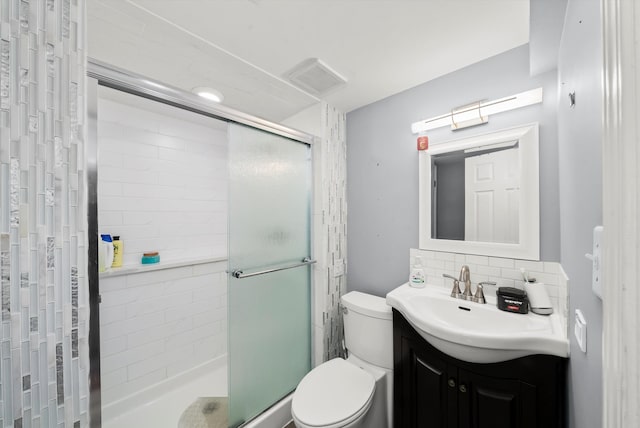 bathroom with decorative backsplash, a shower stall, toilet, and vanity