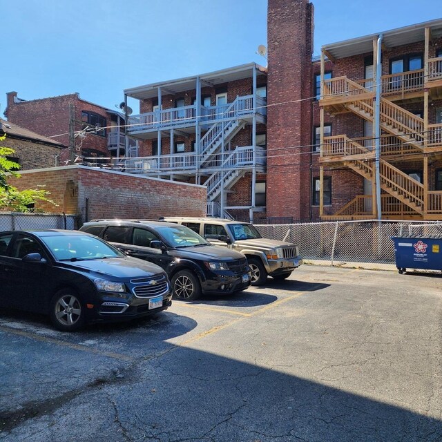 view of building exterior featuring uncovered parking and fence