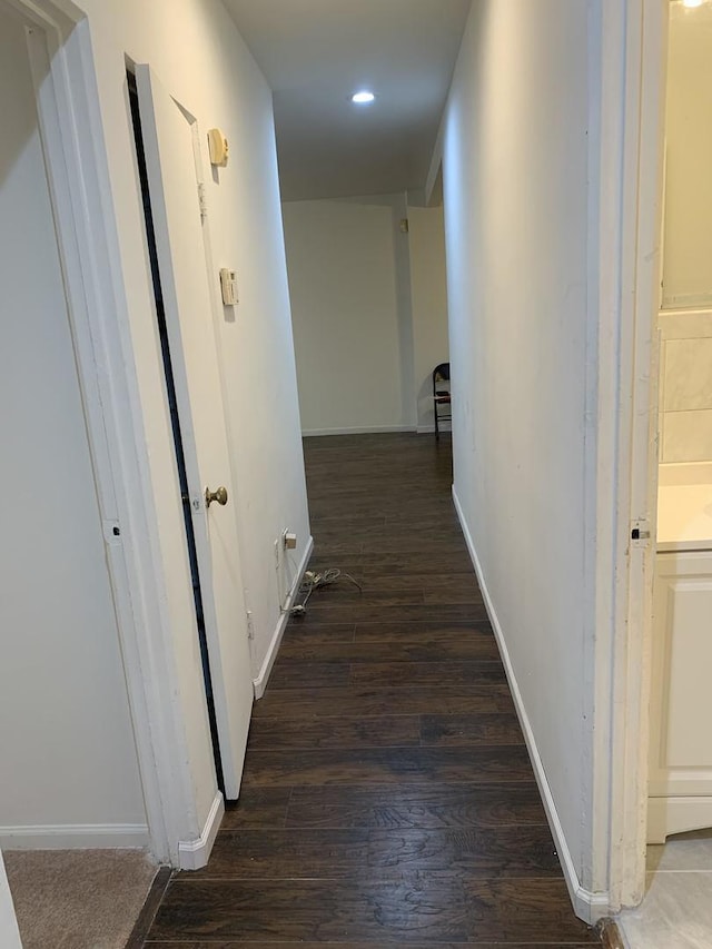 corridor with recessed lighting, wood finished floors, and baseboards