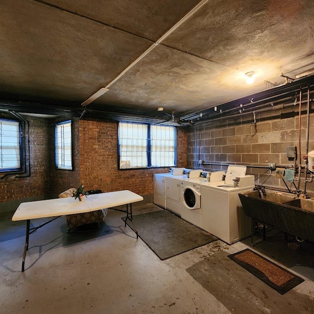 basement featuring washer and clothes dryer and concrete block wall