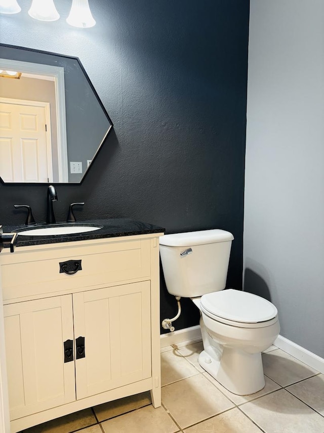 bathroom with tile patterned flooring, toilet, vanity, and baseboards