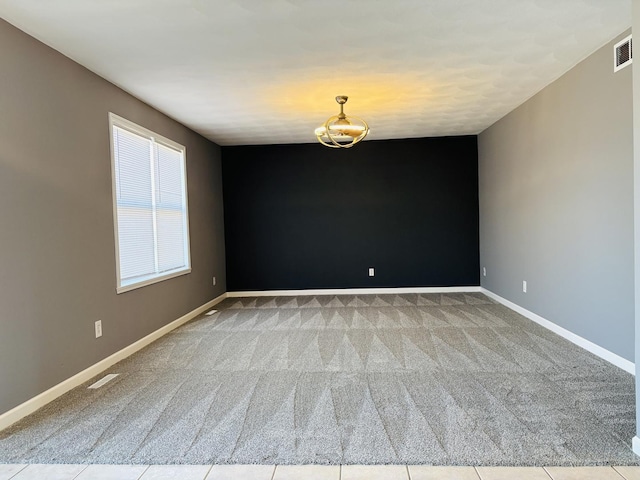 empty room featuring visible vents, carpet, and baseboards