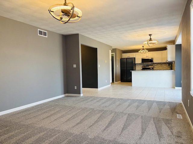 unfurnished living room with light carpet, visible vents, baseboards, and light tile patterned floors