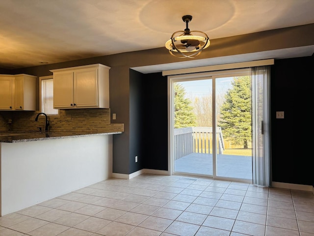 kitchen with light tile patterned flooring, decorative backsplash, and plenty of natural light