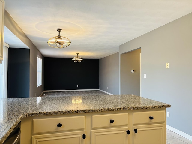 kitchen with baseboards, stone counters, light tile patterned flooring, pendant lighting, and stainless steel dishwasher